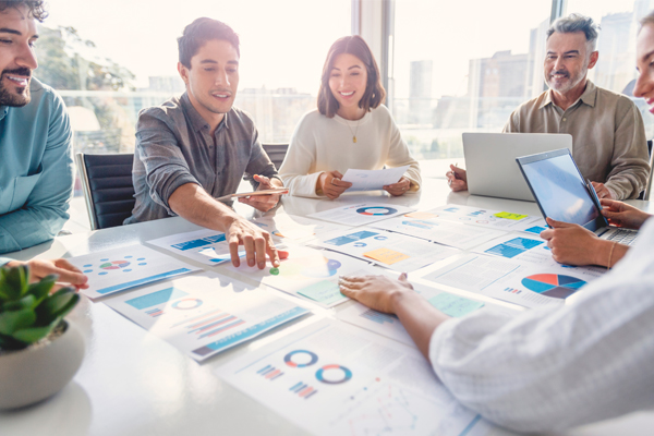 a group of coworkers collaborate around a boardroom table